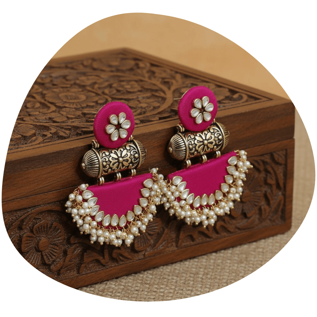Pink Fabric Kundan Earrings resting on carved wooden box
