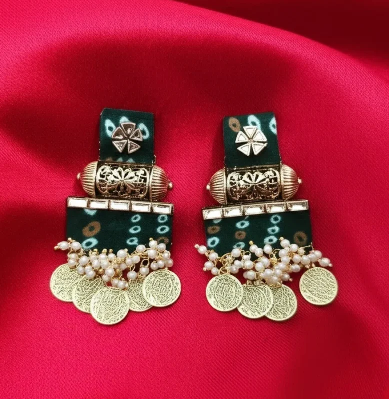 A pair of traditional green earrings with a white Bandhani tie-dye print, decorated with kundan work and hanging gold temple coins.