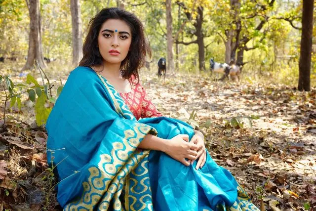 Indian Woman in Cyan Saree sitting in Woods