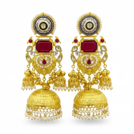 A pair of grand gold tone jhumka earrings with rectangular ruby red stones, preacock design, green enamel, and pearl detailing white background