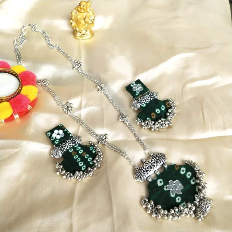 Handmade necklace and earring set with green bandhani fabric, oxidized silver metal, mirror work, and dangling ghungroo beads.