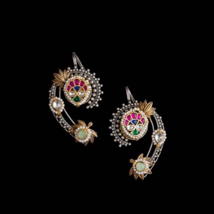 Pair of Kundan earcuffs with gold and silver details, colorful stones, and pearls displayed on a black background