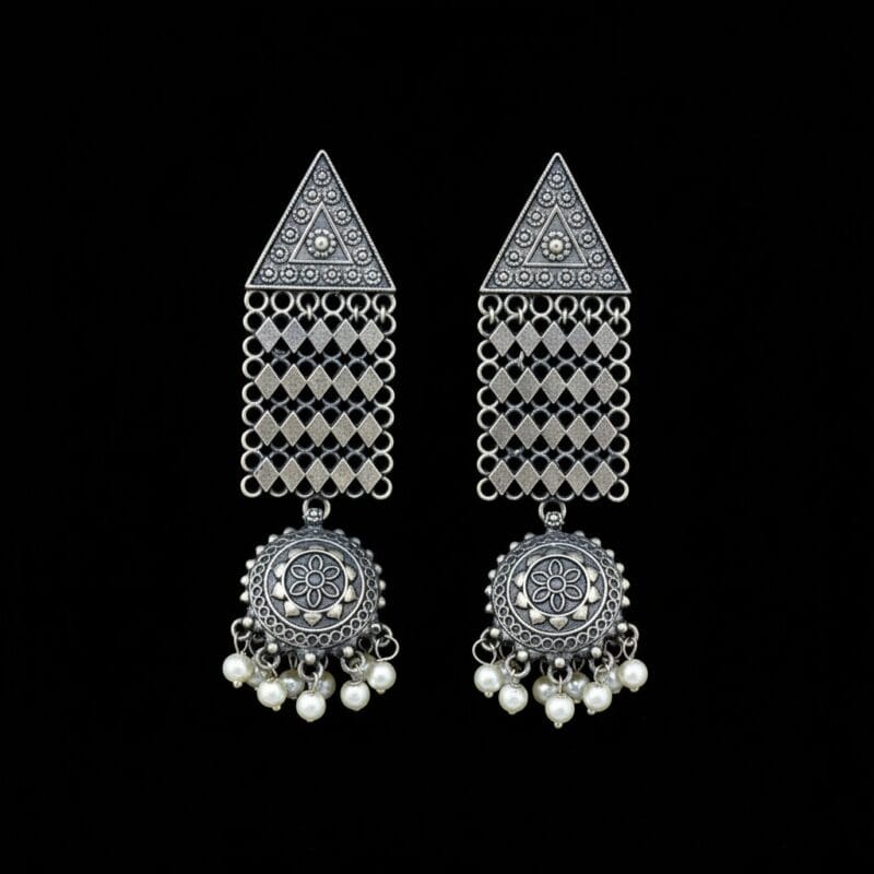 Pair of oxidized silver look triangle jhumka earrings with white pearl drops on a black background