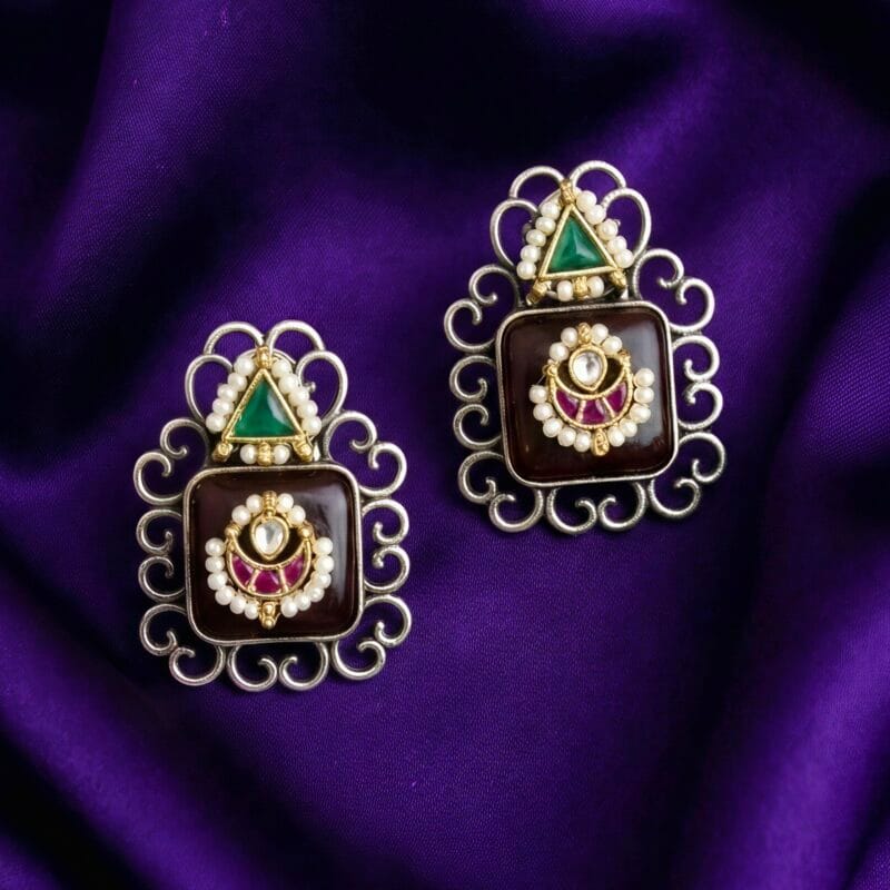 Two pairs of traditional brass Monalisha stone stud earrings. Pair has black stones it intricate silver frames and pearl accents.