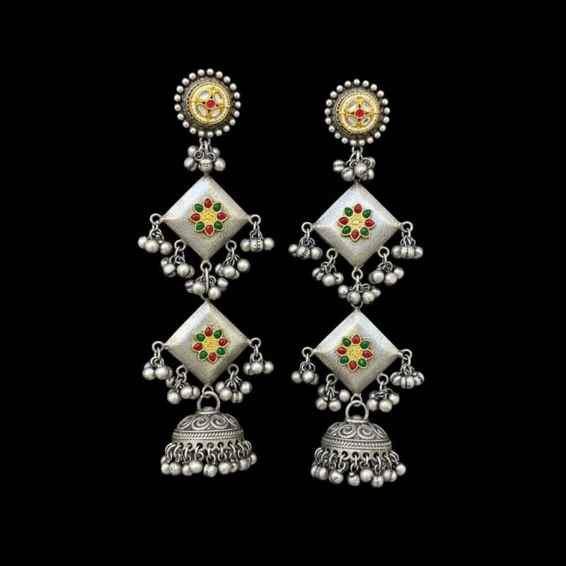 A pair of long traditional oxidized silver look jhumka earrings featuring square elements with red, green, and yellow artificial stones placed on black bg