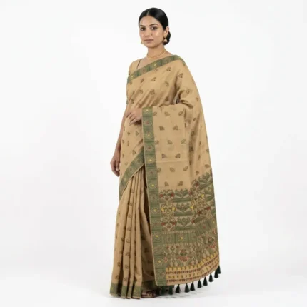 Woman Wearing beige bamboo cotton saree with green woven border and dark green tassels.