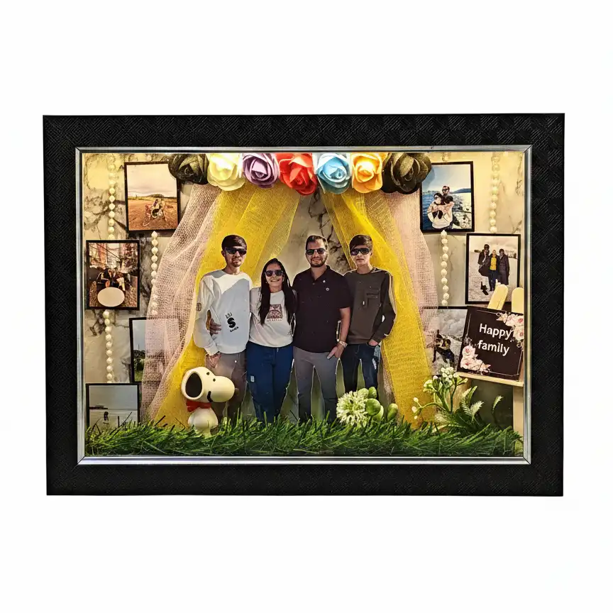 happy-family-3d-miniature-led-frame-gif41 Deluxe 3D shadow box frame in black with a family scene, lit-up family photo cutouts, yellow fabric drapes and small Snoopy collectible figure on grass.